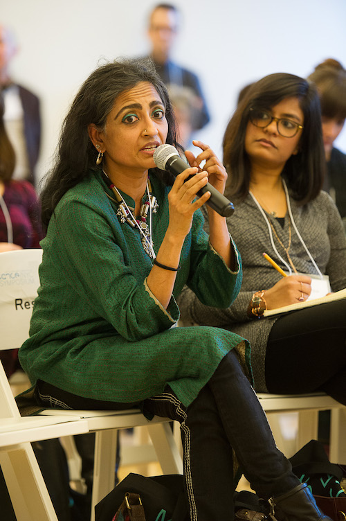 A woman in a bright green tunic in the audience speaks during the Diversity in Dance Education panel